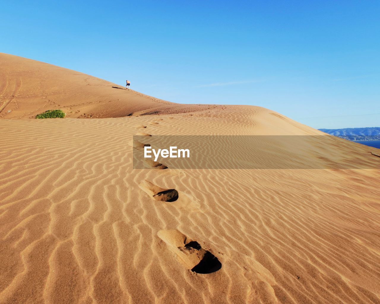 Sand dunes in desert against clear sky