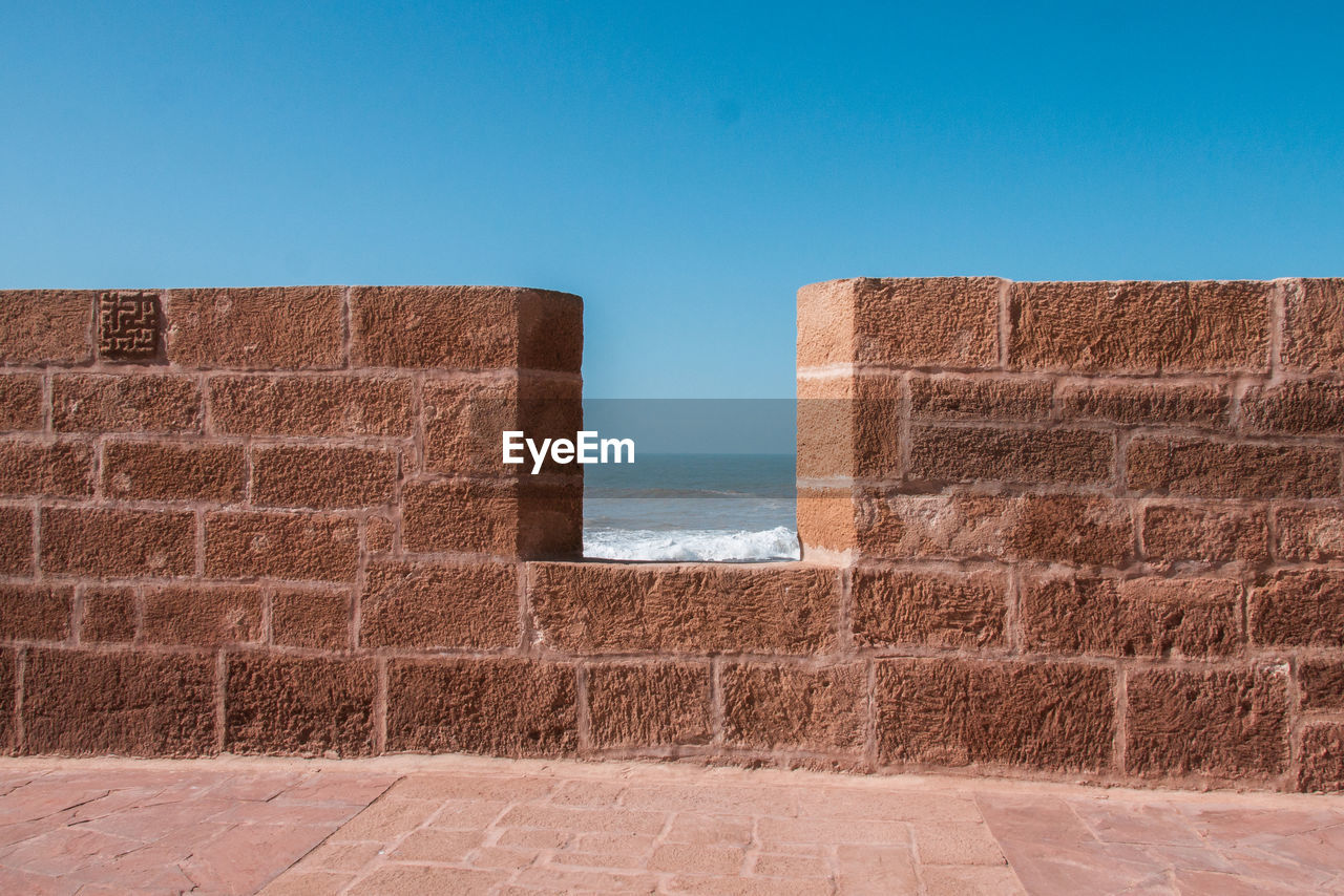 Brick wall against clear blue sky