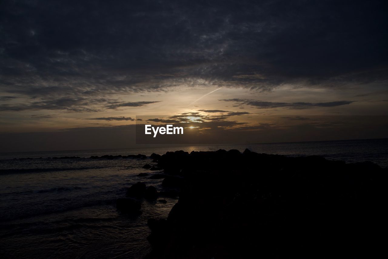 SILHOUETTE BEACH AGAINST SKY DURING SUNSET