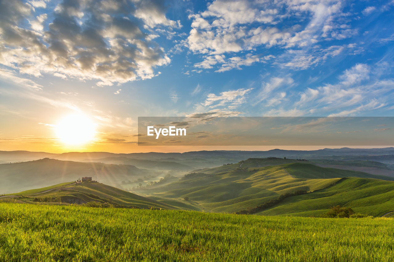 Sunrise in tuscan with rolling rural landscape in mist