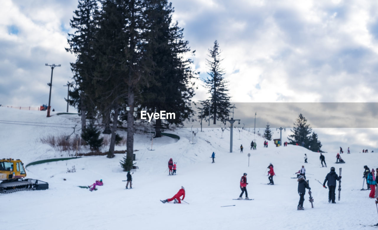 People enjoying on snow covered landscape