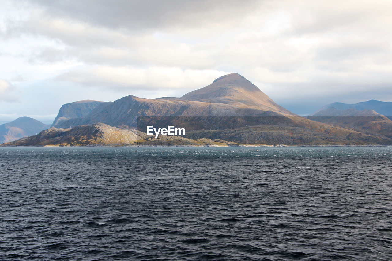 Scenic view of sea and mountains against sky