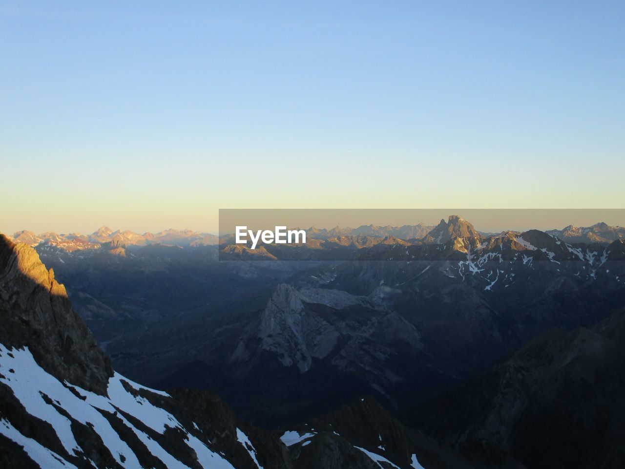 Scenic view of snowcapped mountains against clear sky