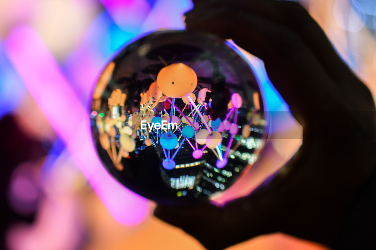 CLOSE-UP OF HAND HOLDING ILLUMINATED LIGHT PAINTING