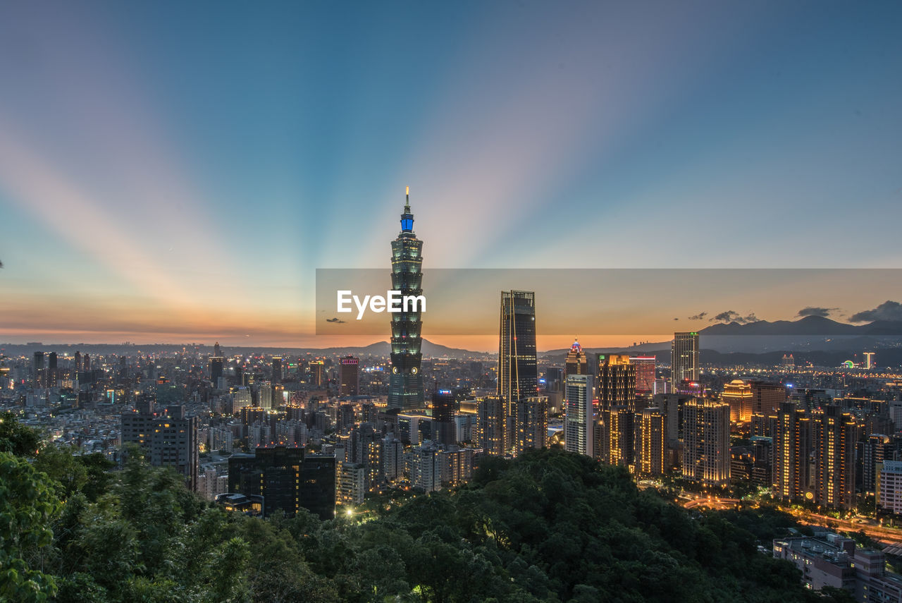 Illuminated buildings in city against sky