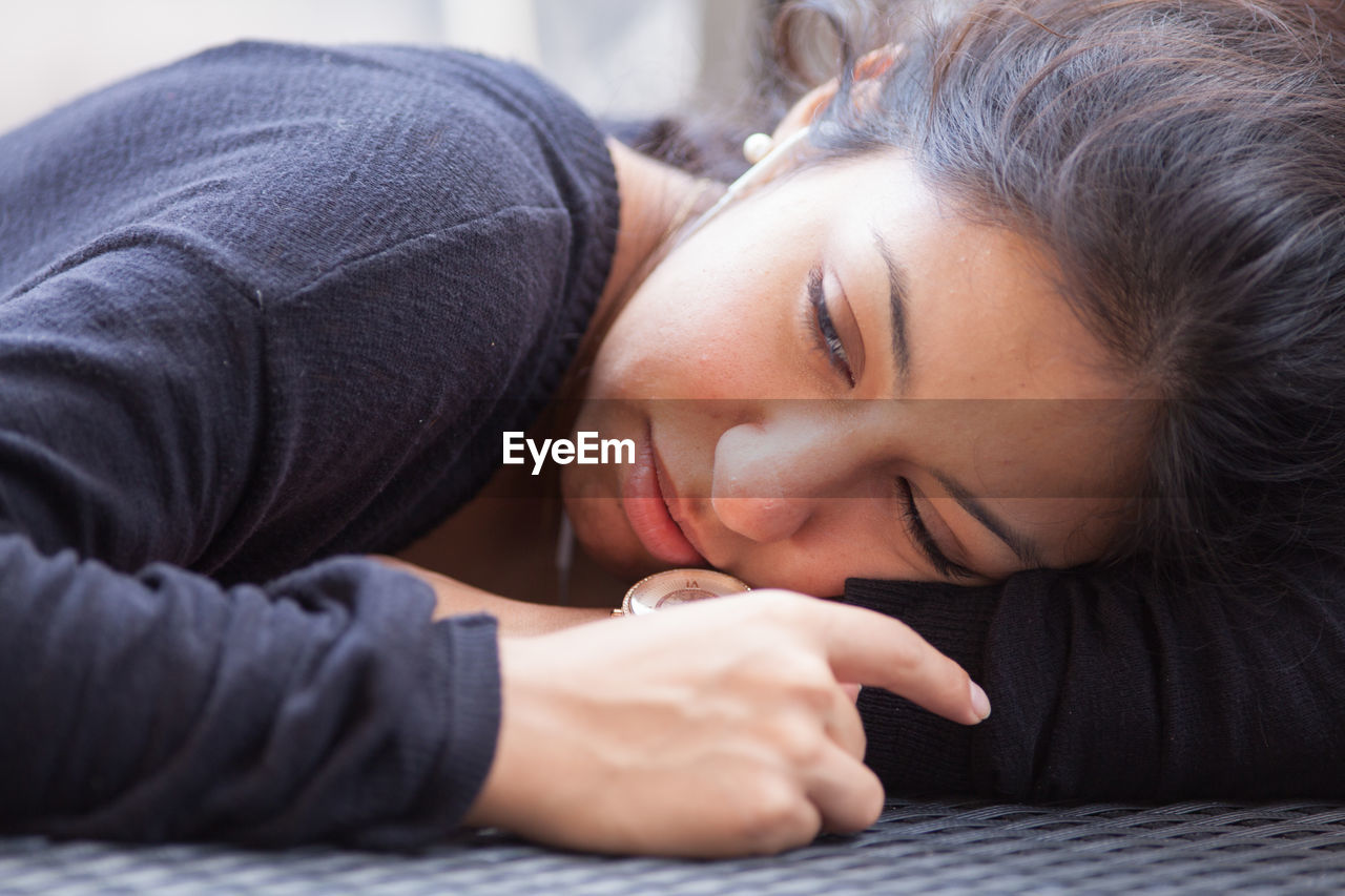 Close-up of young woman lying on table