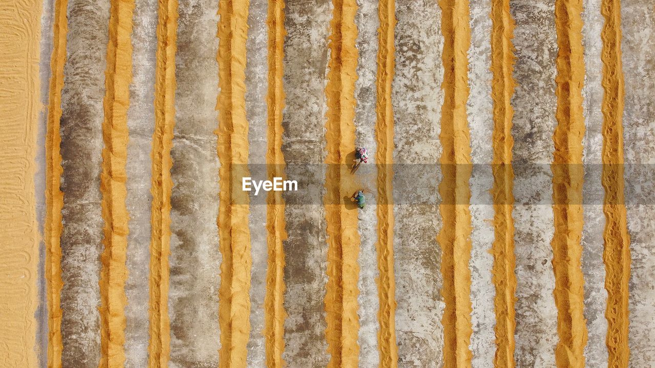 FULL FRAME SHOT OF WEATHERED WALL WITH YELLOW UMBRELLA