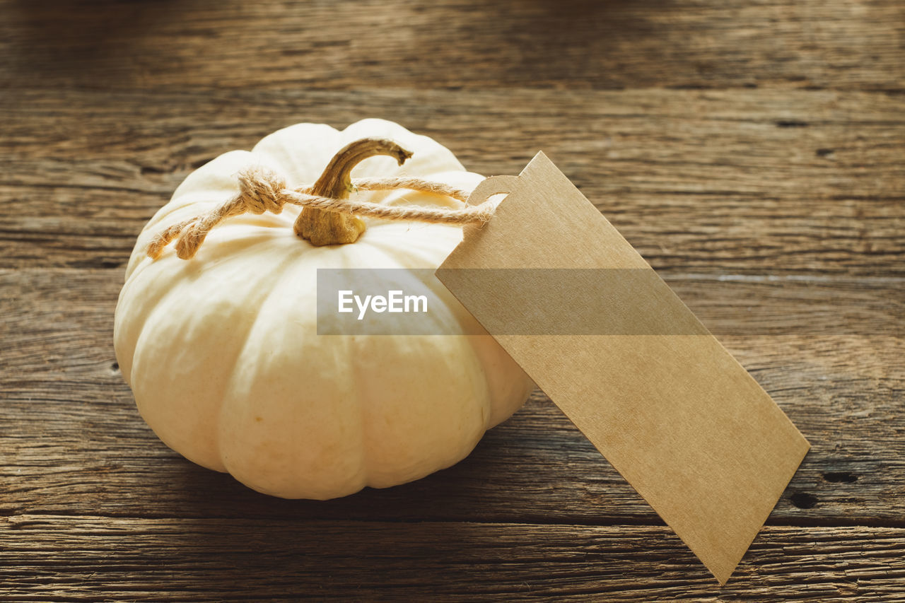 CLOSE-UP OF PUMPKIN ON WOODEN TABLE