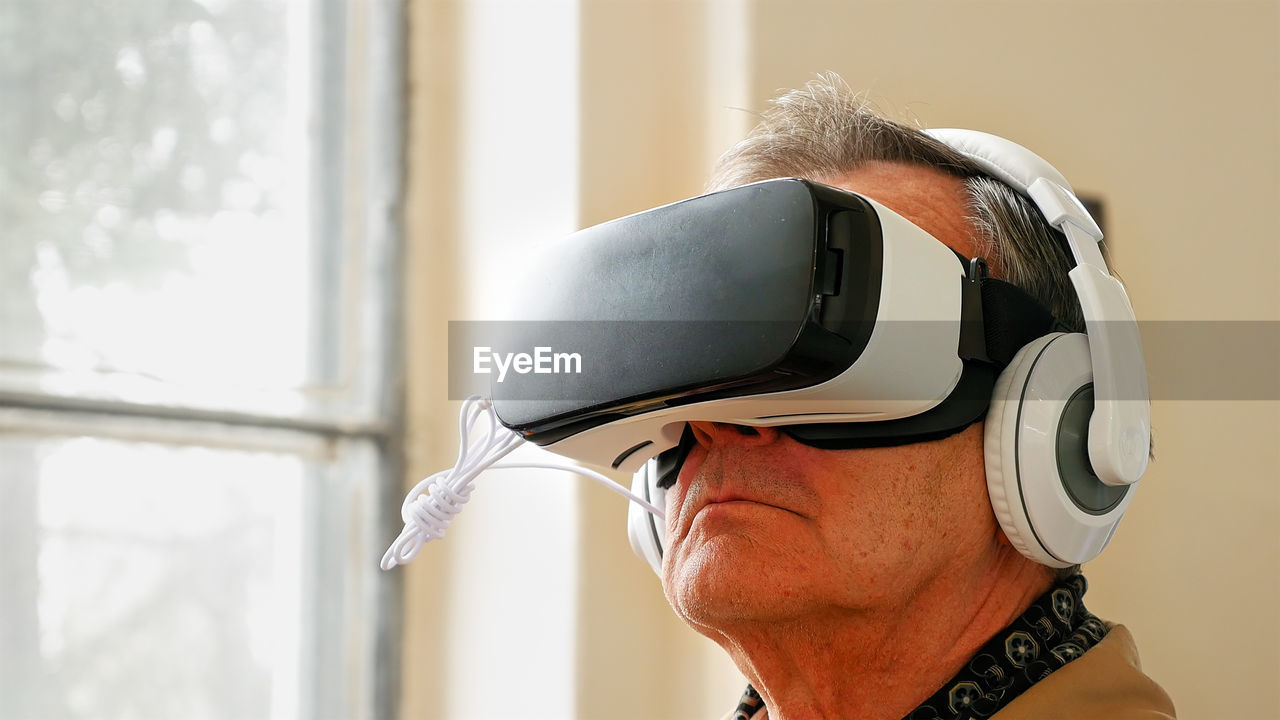 Close-up of senior man looking through virtual reality simulator