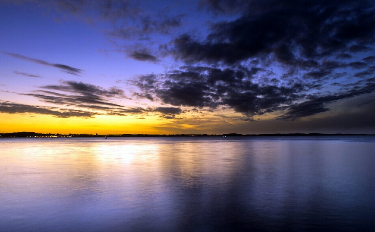 Reflection of clouds in sea at sunset