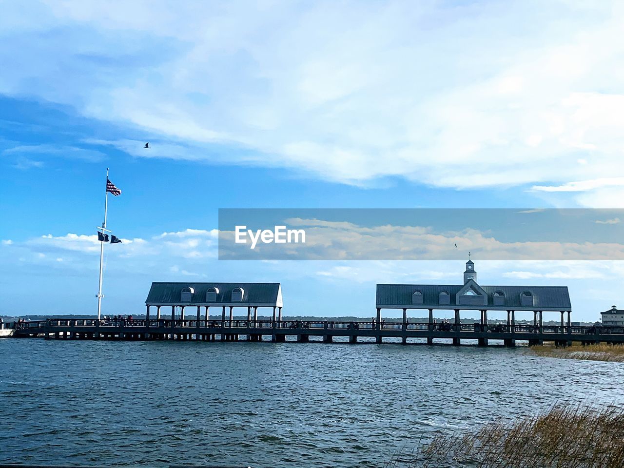 PIER OVER SEA AGAINST CLOUDY SKY