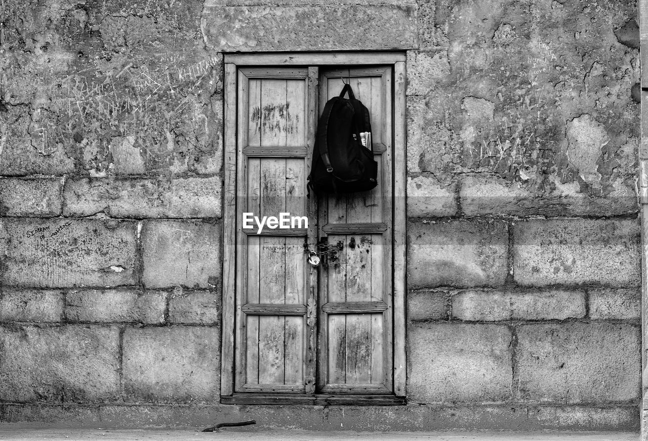 WOMAN STANDING BY WINDOW ON WALL