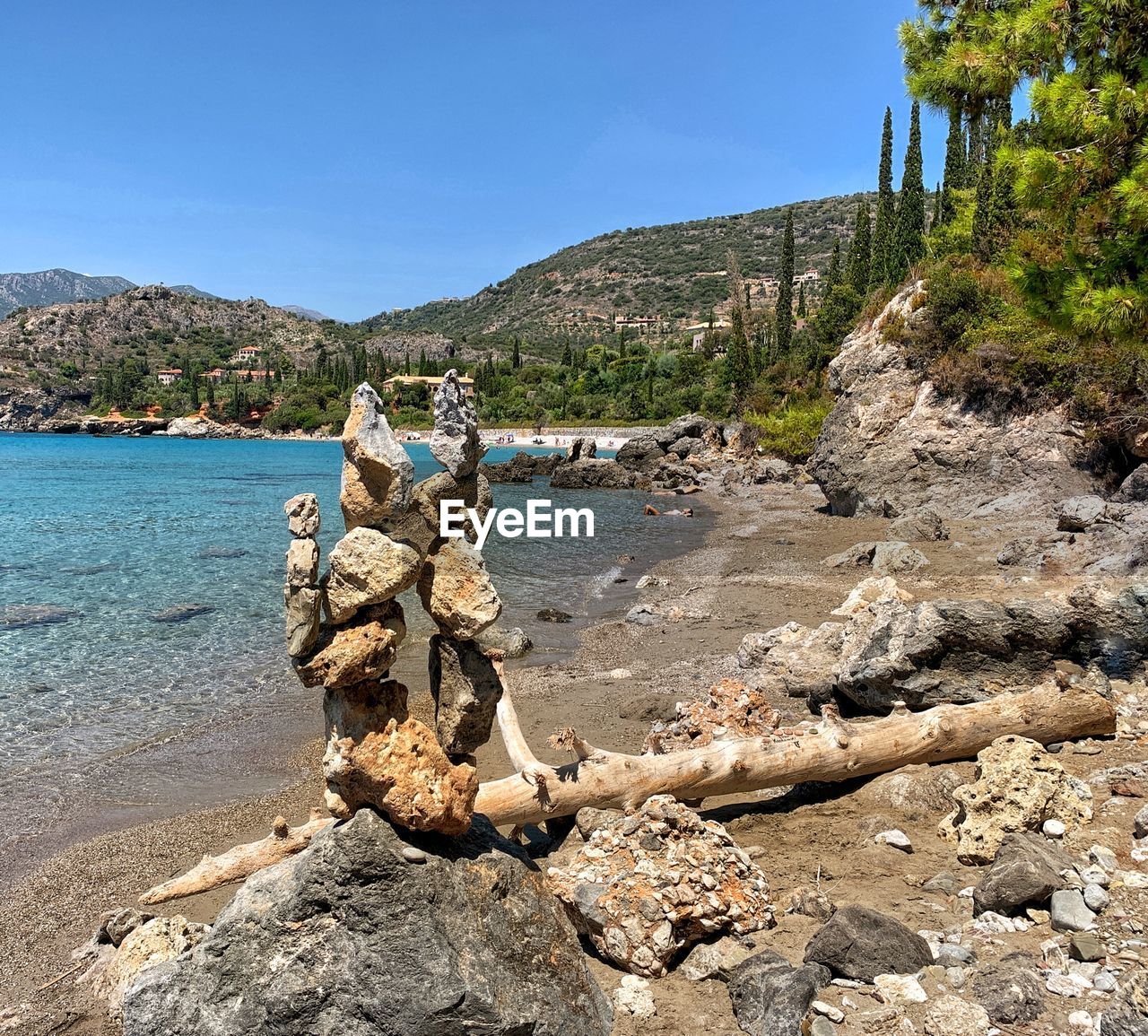 ROCKS ON SHORE AGAINST CLEAR SKY
