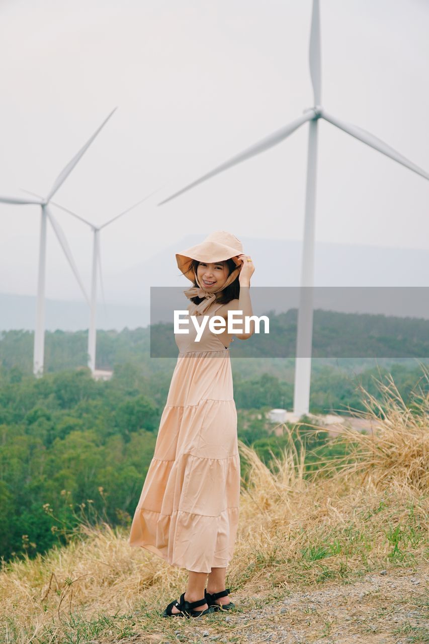 Woman wearing hat standing on field