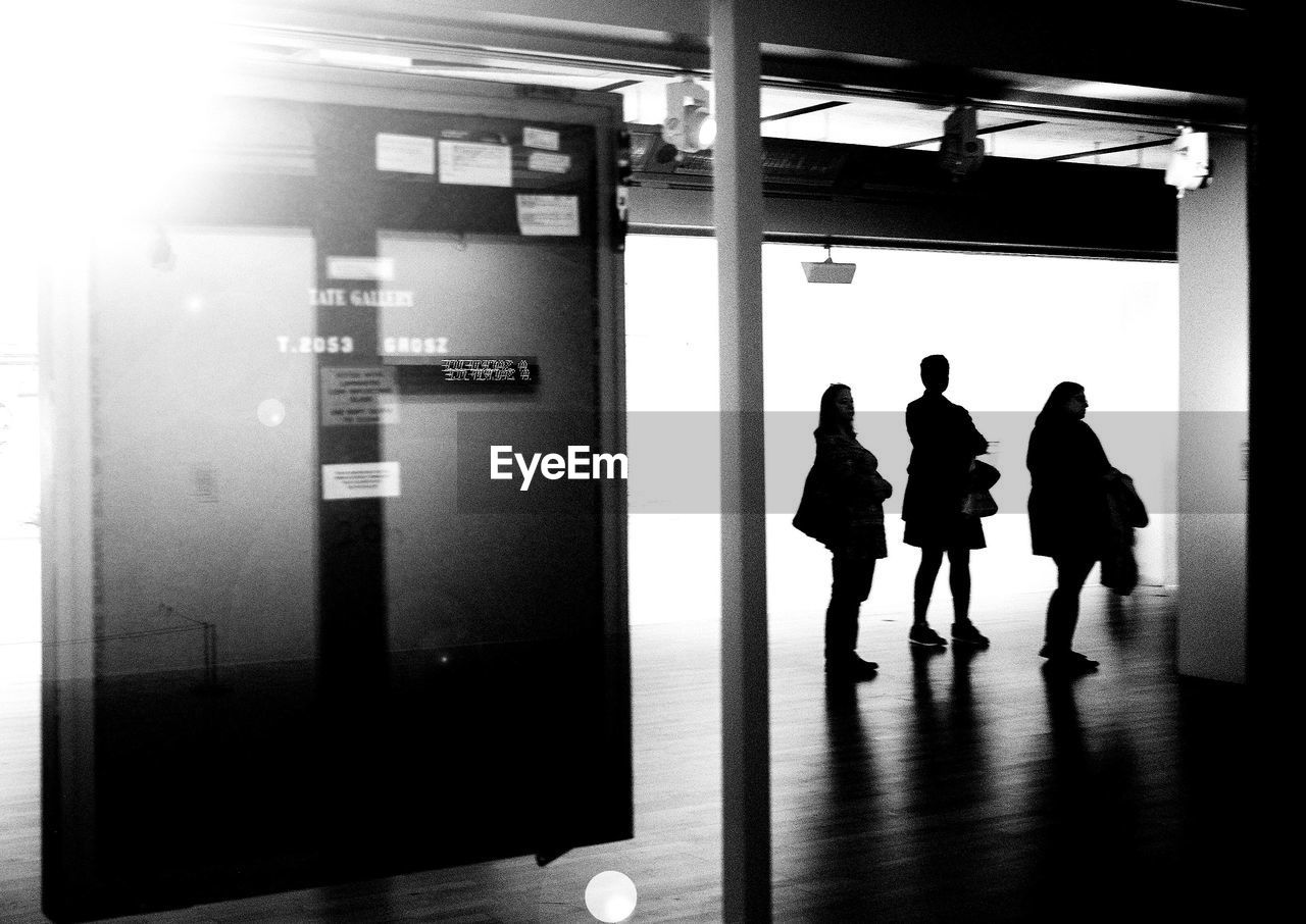 PEOPLE WALKING IN ILLUMINATED UNDERGROUND