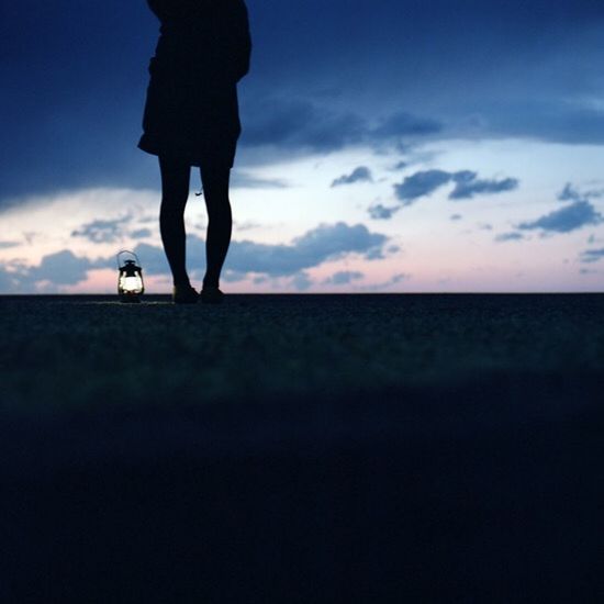 SILHOUETTE OF WOMAN STANDING AGAINST CLOUDY SKY
