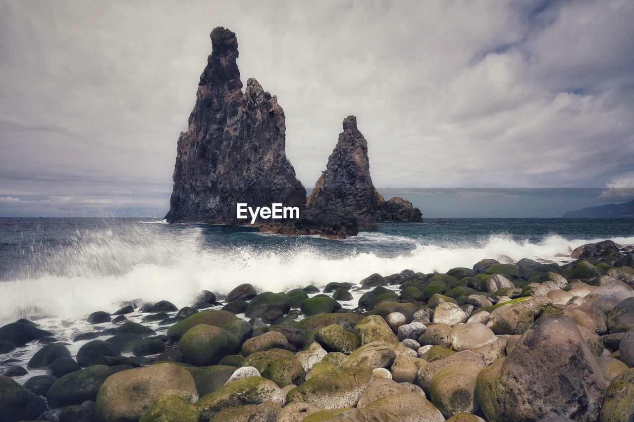 Scenic view of rocks in sea against sky