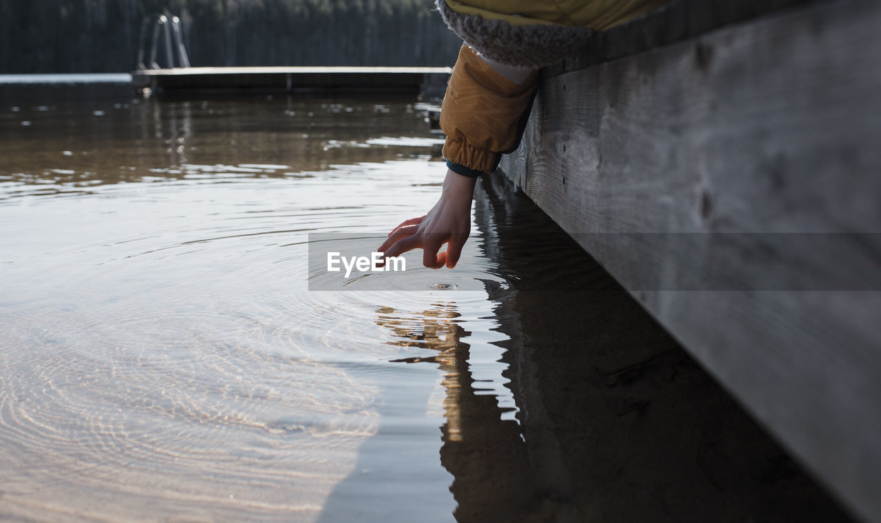 Child's hand flicking sea water at the beach in sweden