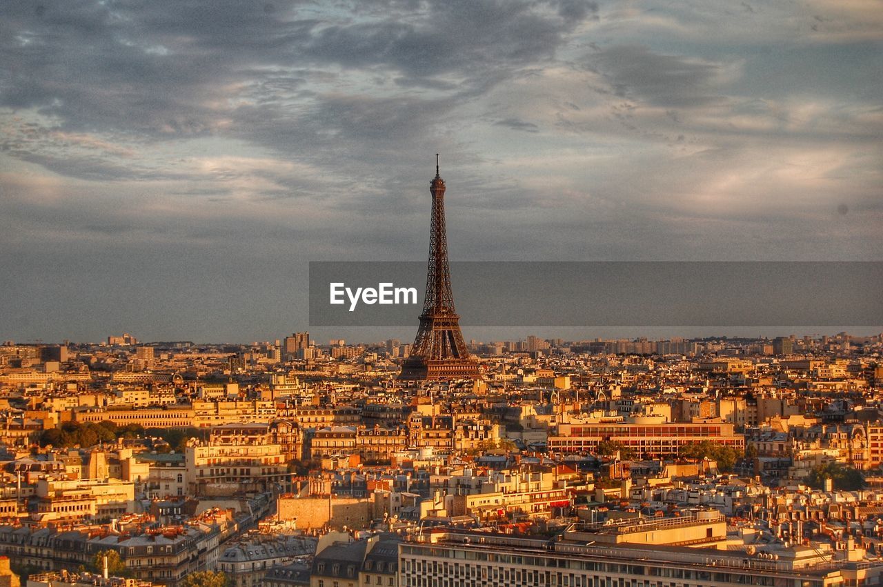 Aerial view of city buildings against cloudy sky