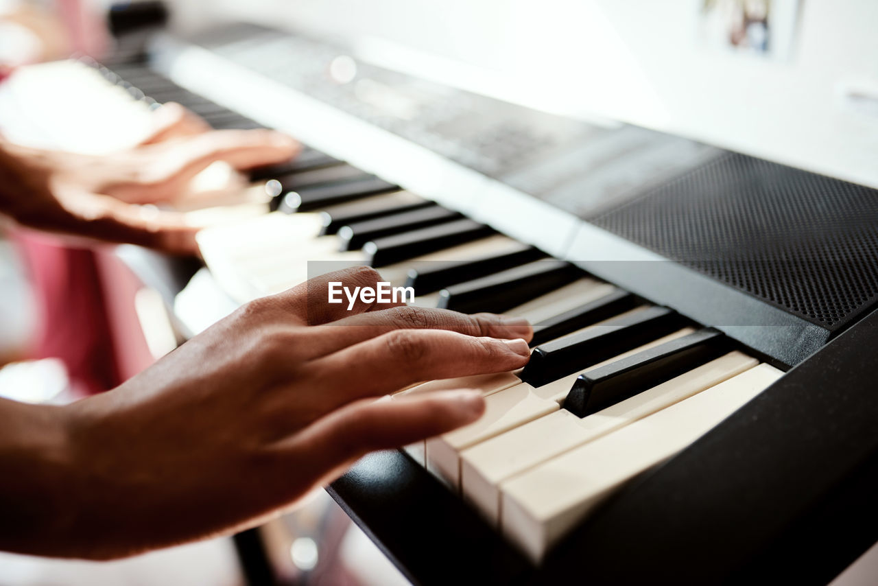 cropped hands of person playing piano
