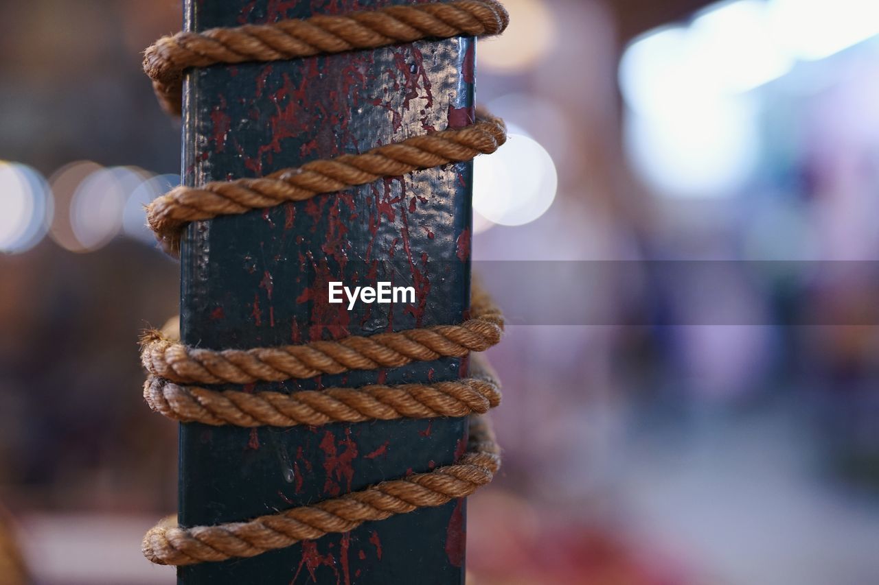 Close-up of rope tied up on rusty metal