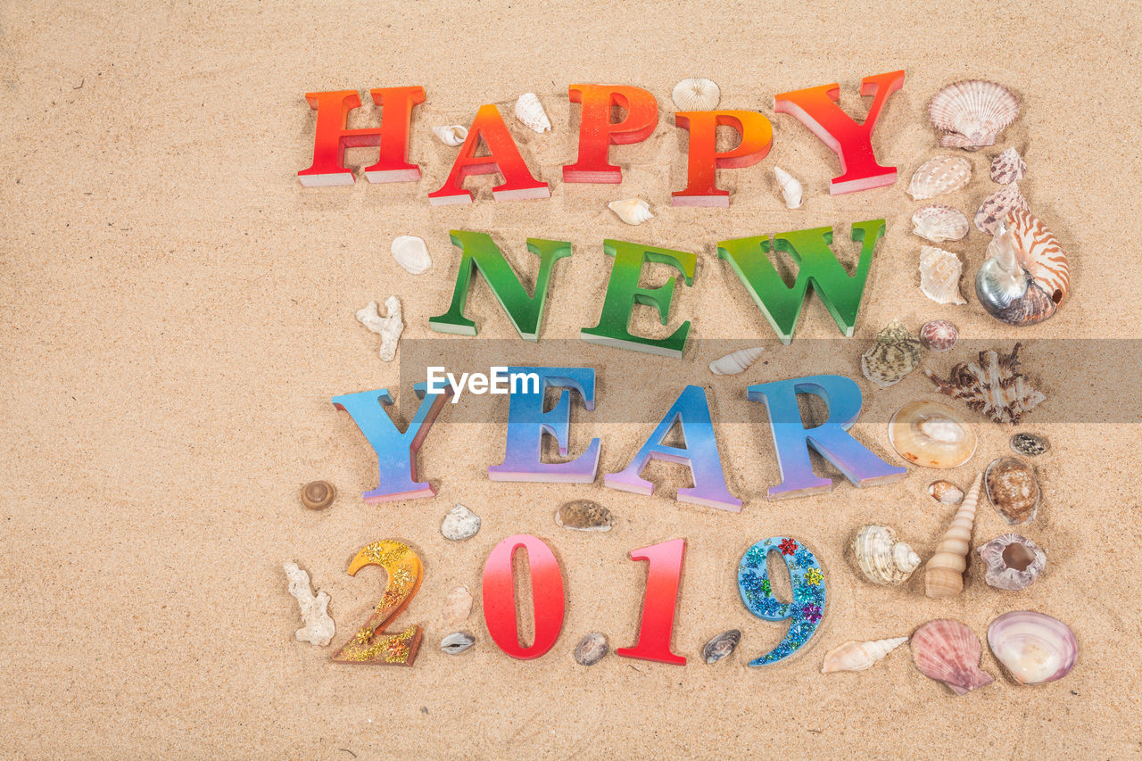 Happy new year text on sand