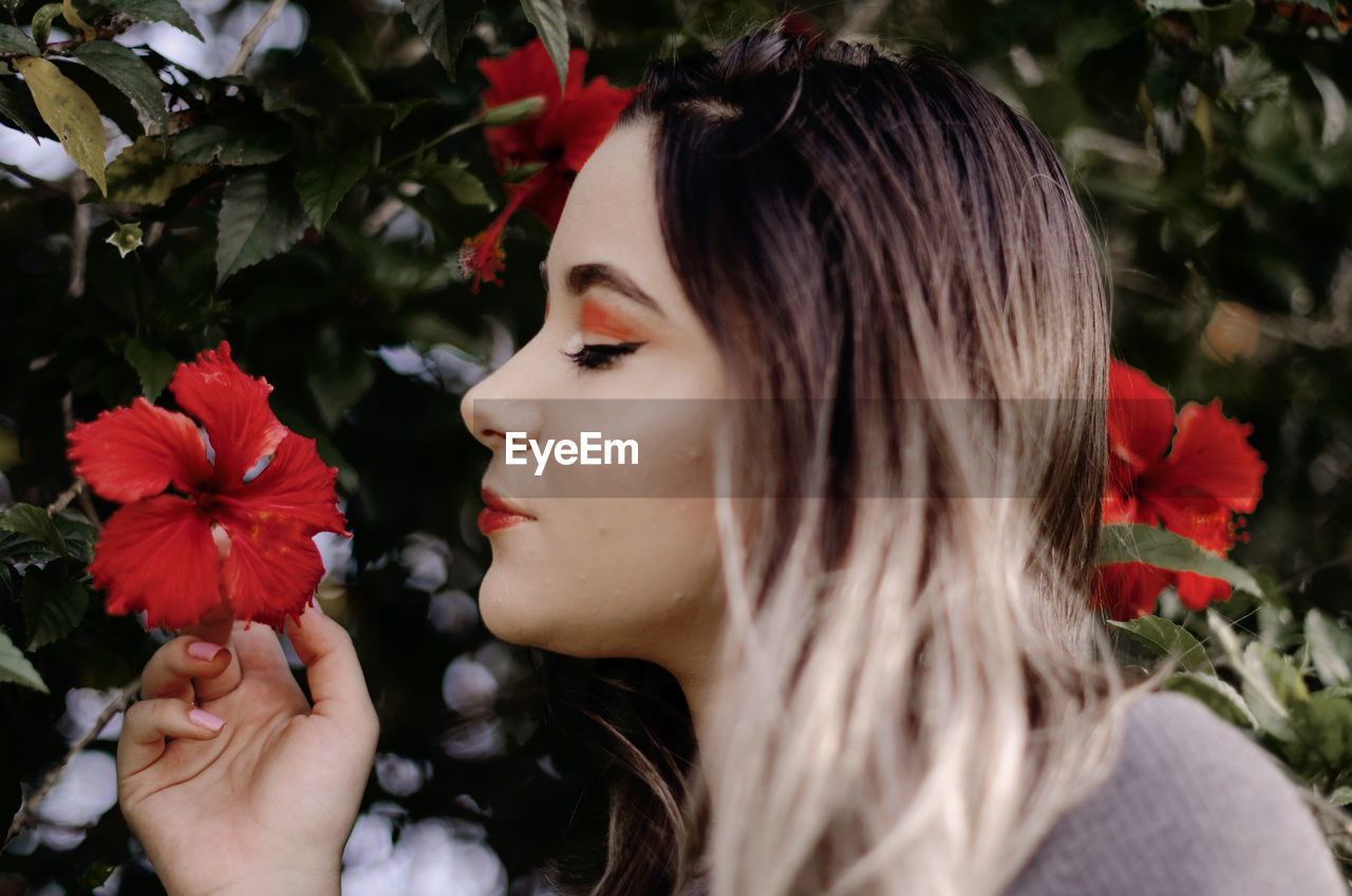 Close-up of woman with red flower