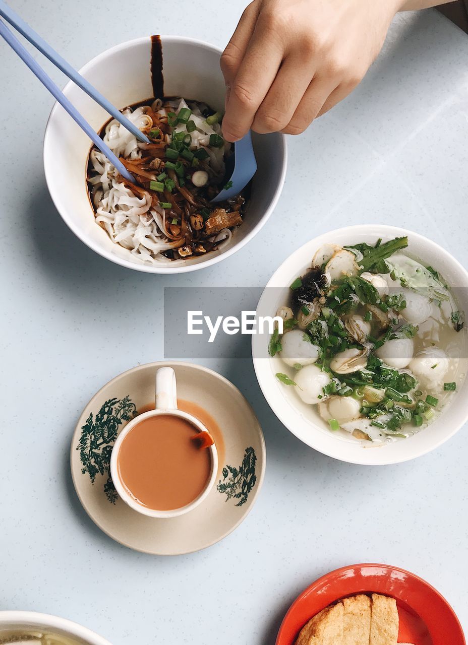 Cropped hand having food at table