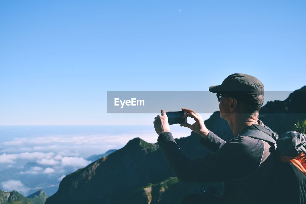 Man photographing against sky