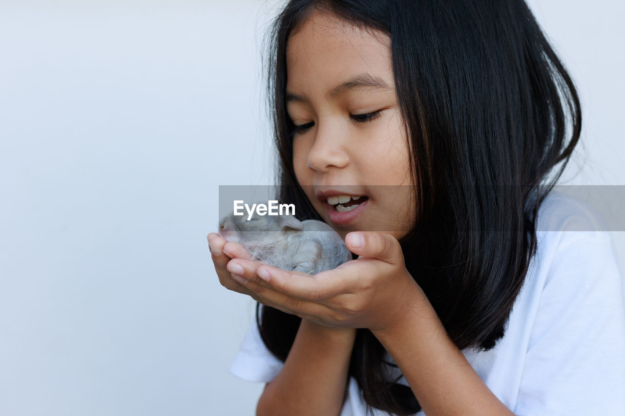 Close-up of girl holding baby rabbit