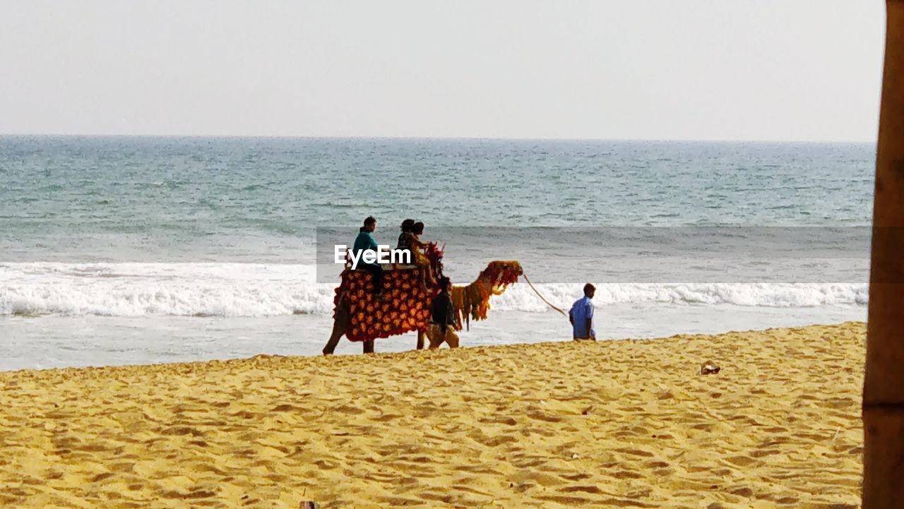 FRIENDS STANDING ON BEACH