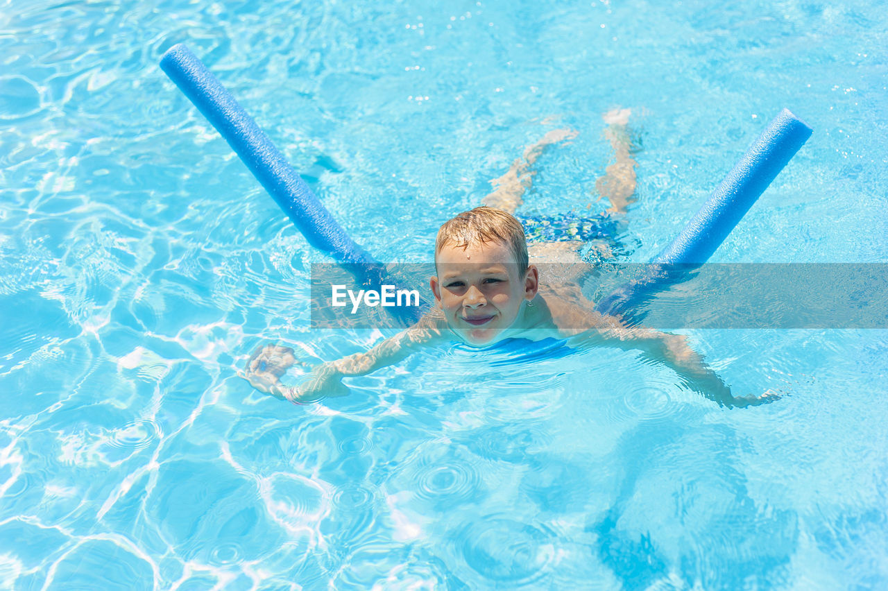 Portrait of smiling boy swimming in pool