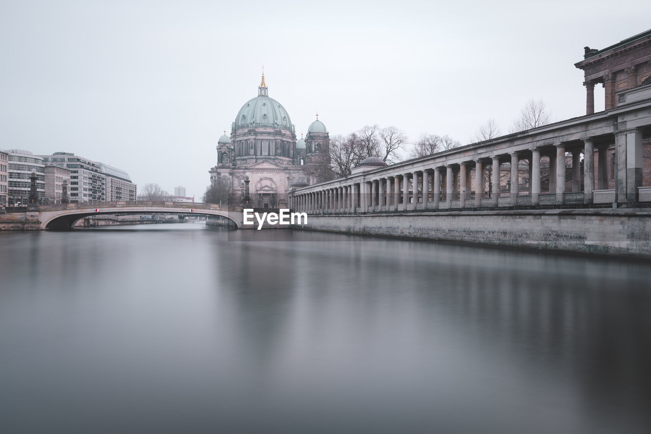 Bridge over spree river by berlin cathedral against sky in city