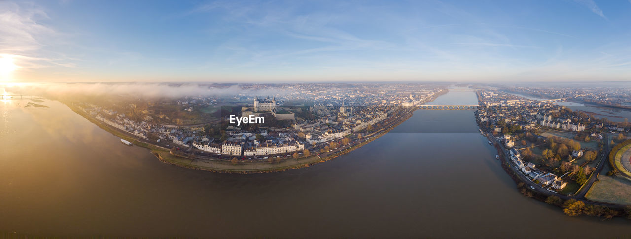 Aerial drone view of saumur medieval castle, saint peter church and loire river at sunrise, france