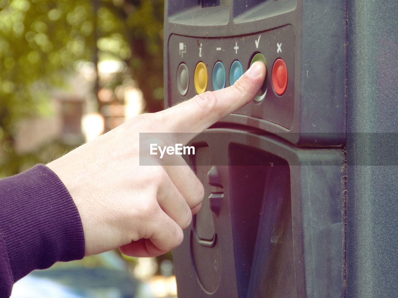 Cropped hand of person pressing button on machine