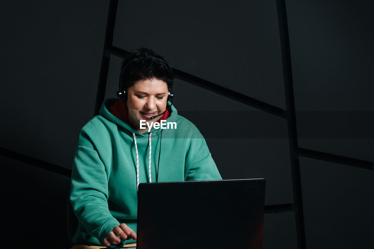 PORTRAIT OF YOUNG MAN USING LAPTOP AT HOME