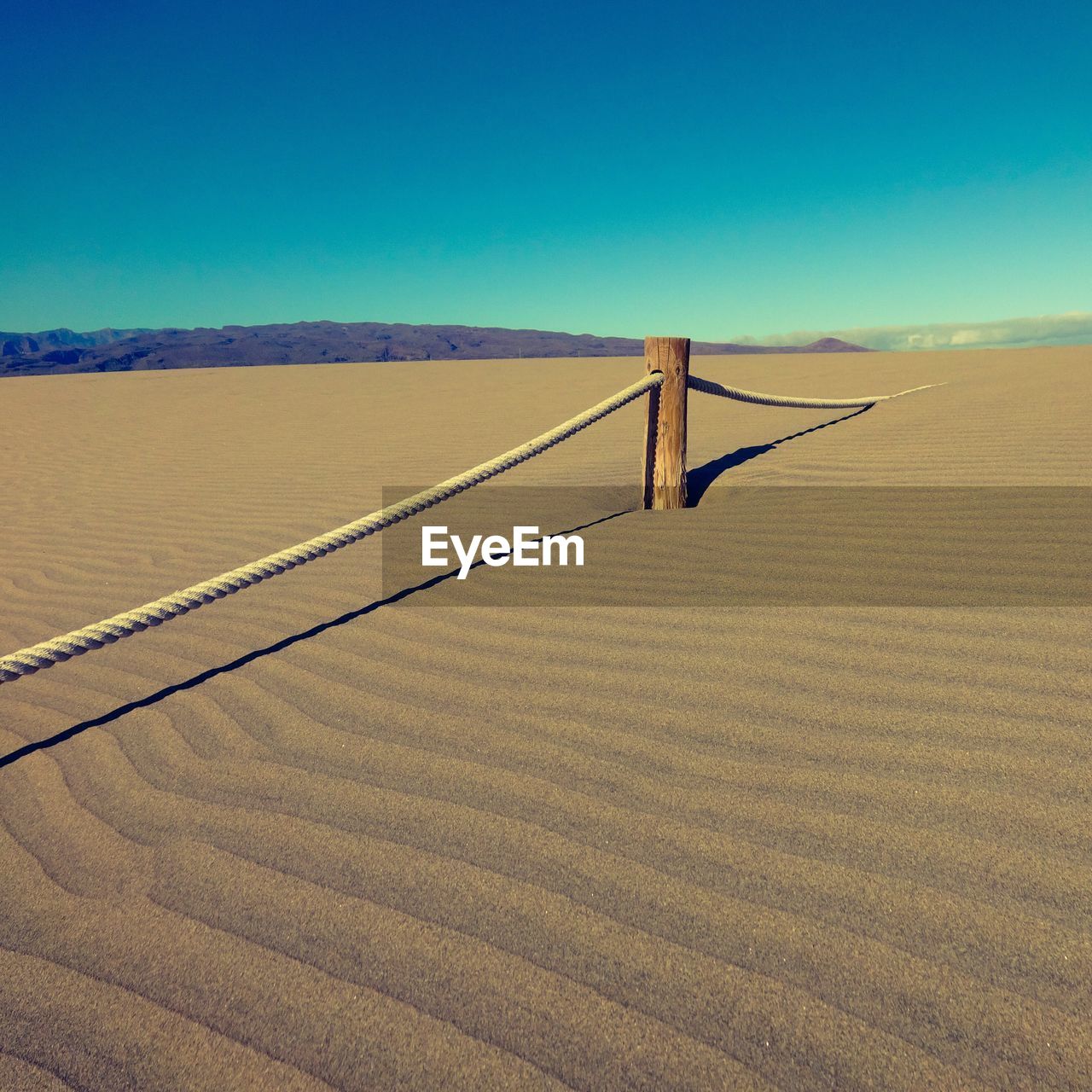 Scenic view of desert against clear blue sky