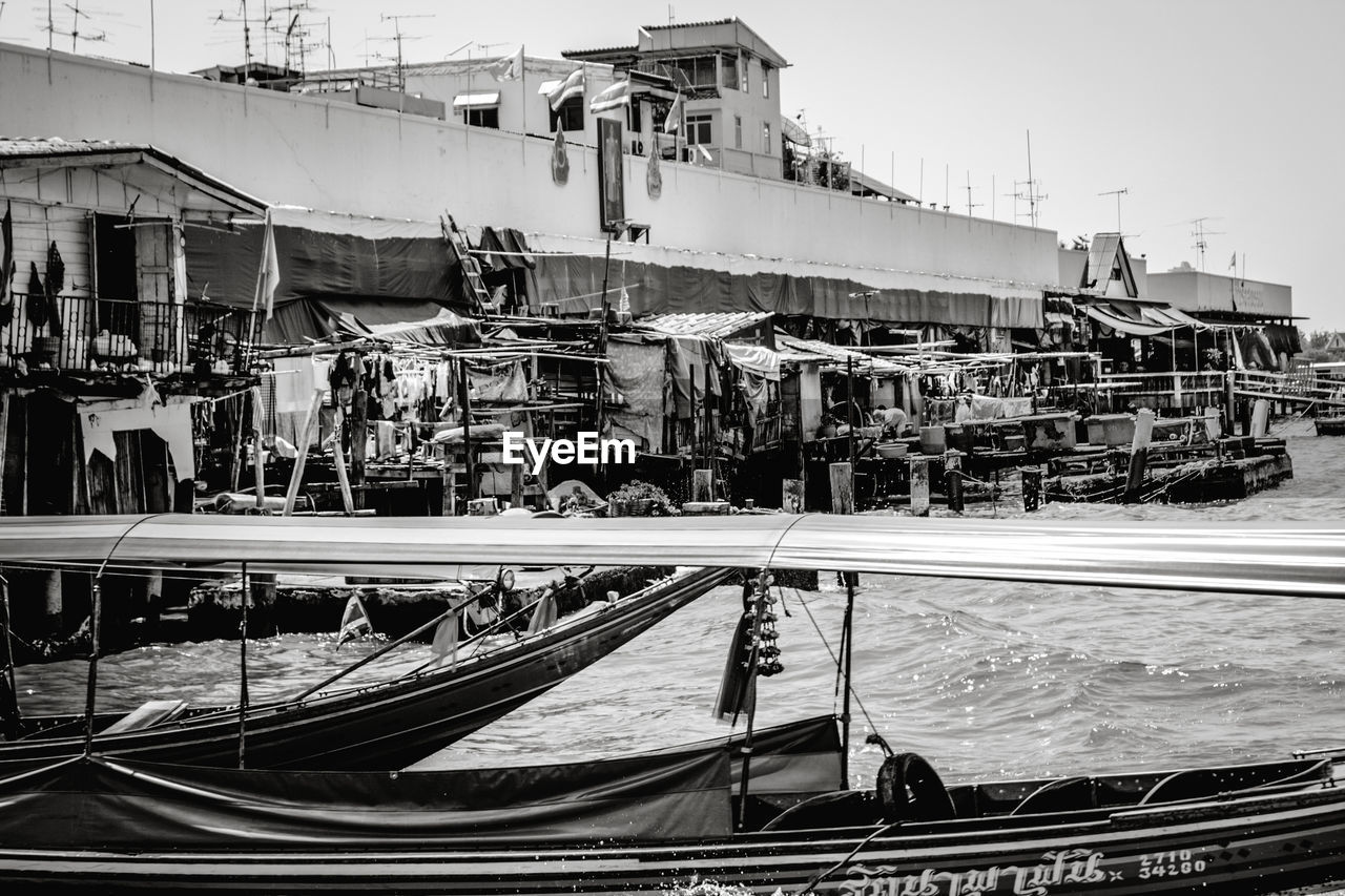 SHIP MOORED AT HARBOR AGAINST SKY