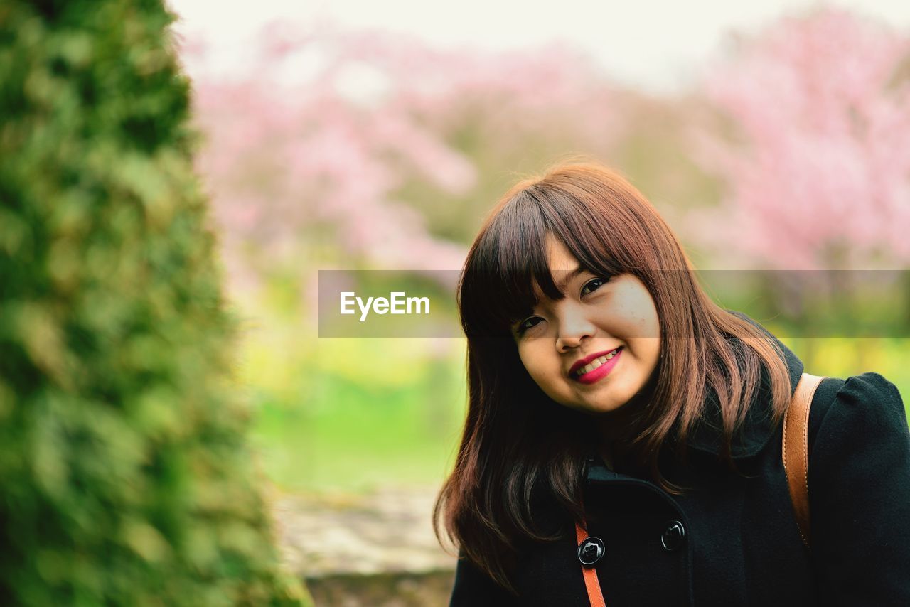 Portrait of smiling beautiful woman in park