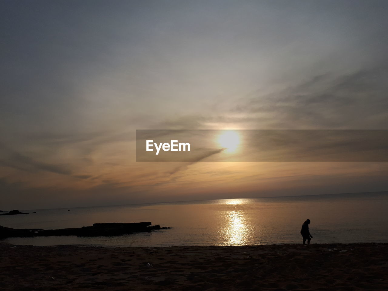 SILHOUETTE MAN STANDING ON BEACH AGAINST SKY DURING SUNSET