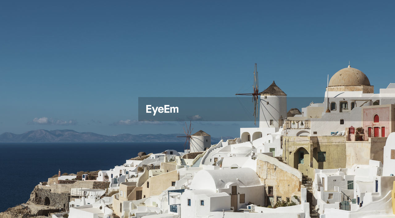 Buildings by sea against sky in city