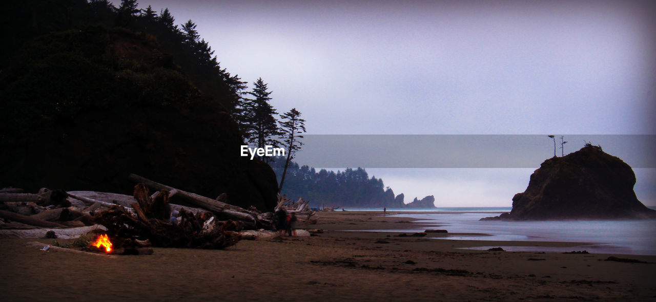 land, beach, water, sea, nature, sky, darkness, rock, beauty in nature, coast, evening, scenics - nature, no people, tranquility, sand, night, outdoors, dusk, tranquil scene, travel destinations, coastline, terrain, environment, sunset, ocean, tree
