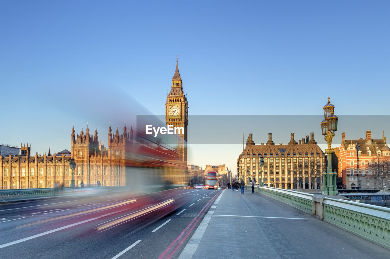 Double-decker bus passes on westminster bridge, in front of westminster palace and clock tower of big ben (elizabeth tower), london, england, united kingdom