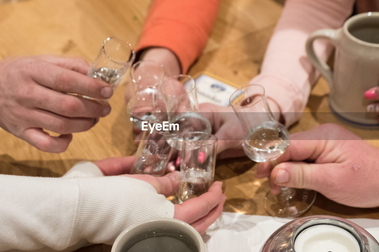 People holding drink on table