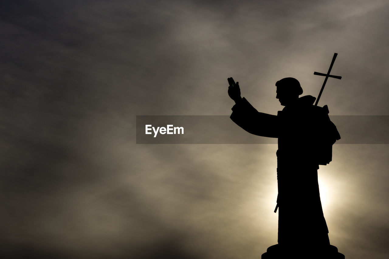 Low angle view of silhouette statue against sky