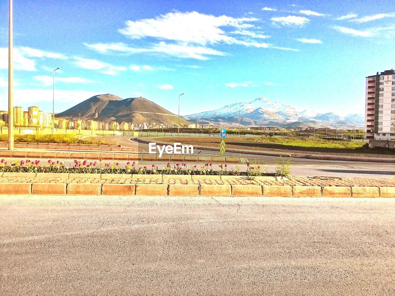 Road with mountains against sky during sunny day