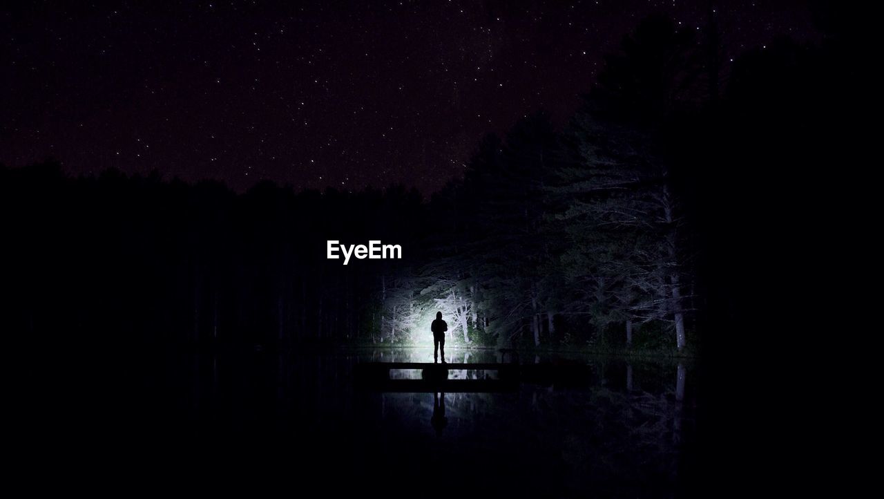 SILHOUETTE PEOPLE STANDING IN FRONT OF DARK SKY