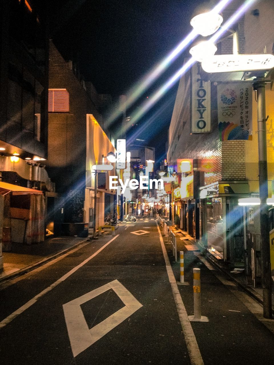 ROAD SIGN ON ILLUMINATED STREET AT NIGHT