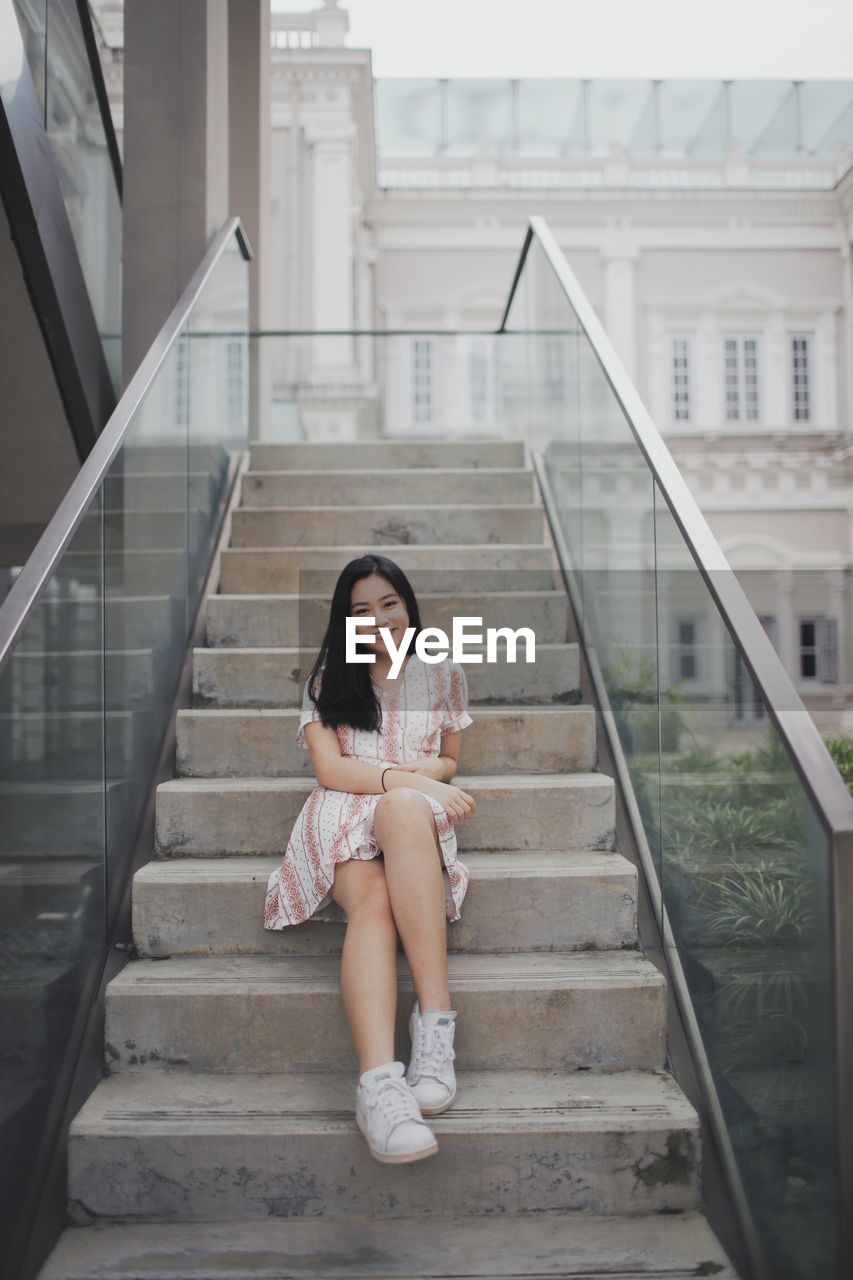 Portrait of young woman sitting on staircase