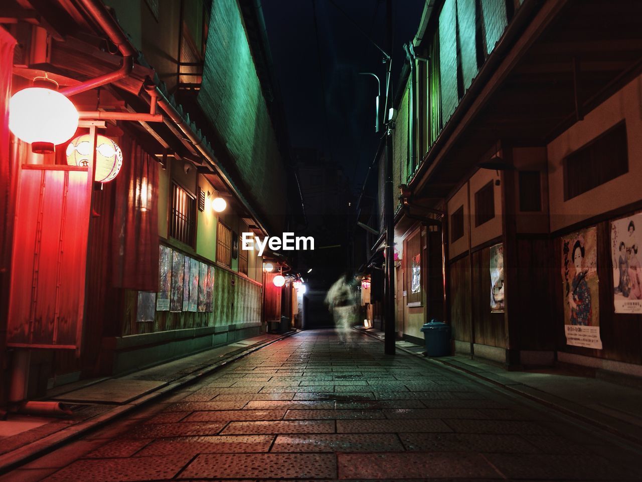 Footpath amidst buildings at night